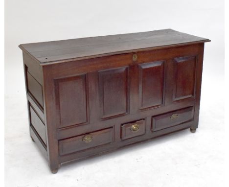 An 18th century oak blanket box with triple panelled hinged lid and carved detail to the front raised on bracket feet, width 