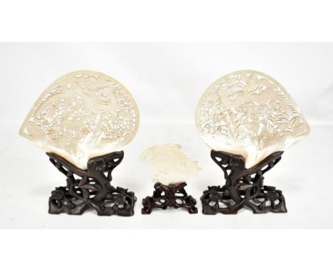 Two Chinese pierced mother of pearl plaques, each mounted on a pierced hardwood and a similar smaller fragment example (3).Ad