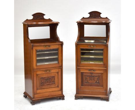 A very near pair of late Victorian walnut music cabinets each with serpentine shelf above mirrored back, fall front enclosing