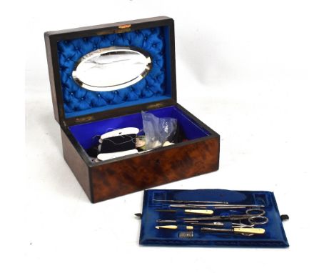 A Victorian amboyna and rosewood crossbanded Victorian sewing box with related sewing tools to the interior, width 25cm.