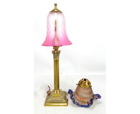 A small brass table lamp with cranberry tinted up turned tulip shaped shade, height 46cm and a further floral moulded shade (