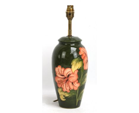 MOORCROFT; a 'Hibiscus' pattern tubeline decorated lamp base on green ground, height excluding fitment 26cm.Additional Inform
