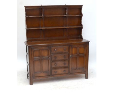 An oak dresser with two shelf boarded plate rack above twin cupboard doors flanking four short drawers, 170 x 144cm.Additiona