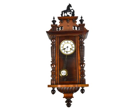 A small Vienna style spring driven walnut and stained beech wall clock with white enamel dial set with Roman numerals, length