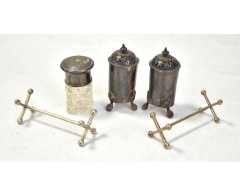 A pair of early 20th century silver peppers raised on three oak leaf capped feet (marks rubbed), a silver topped glass jar (e