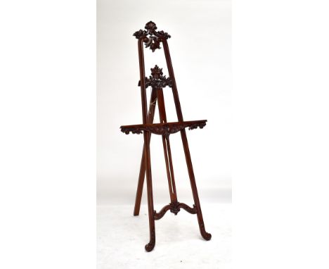 A mahogany easel with carved floral detail throughout and scrolling front supports, height 215cm.
