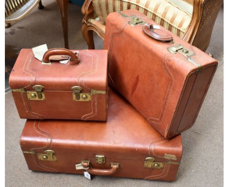 Three vintage stitched leather cases of graduated size, the largest bearing partial labels, 43 x 63.5 x 22cm (3).Additional I