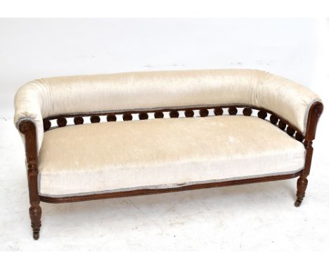 An Edwardian settee with padded rounded back above a gallery of turn stylised flower heads with padded seat and turned front 