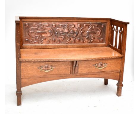 An Arts and Crafts oak hall bench with stylised floral decorated embossed copper panel to the back, pierced invert heart shap