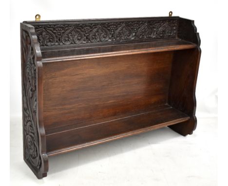 MACCLESFIELD SCHOOL OF CARVING; an oak two tiered wall shelf, width 65.5cm.