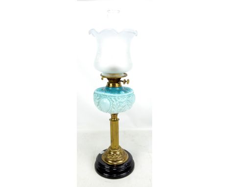 An Edwardian brass column oil lamp with etched floral shade, moulded blue/green tinted reservoir and stepped circular base, h