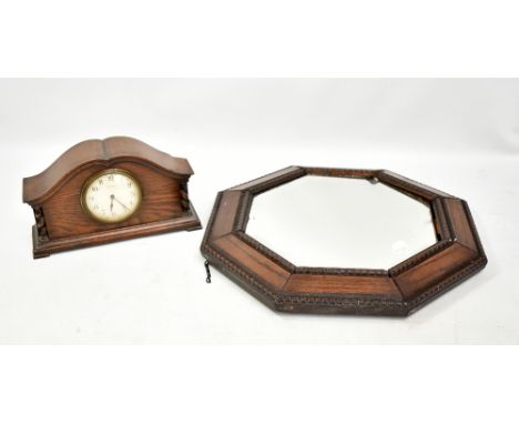 An early 20th century oak mantel clock with shaped case and painted dial, width 27cm, also an octagonal wall mirror (2).&nbsp