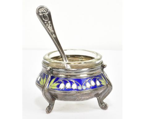 A Russian enamel decorated white metal circular salt with associated clear glass liner and with spoon retaining traces of ori