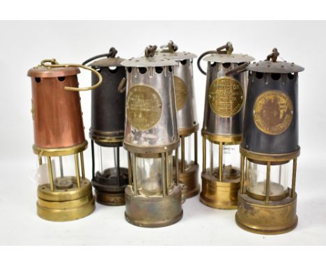 Six miners' safety lamps comprising three Protector Lamp &amp; Lighting Co Ltd examples including Pretwich's Patent, a Berwoo