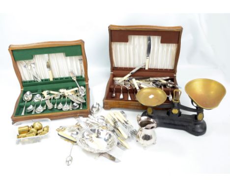 A group of metalware including a pair of scales, brass weights, two cased sets of plated flatware, further plated items, etc.