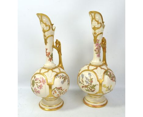 ROYAL WORCESTER; a large pair of floral painted gilt heightened blush ivory ewers, each with raised panels and puce printed m