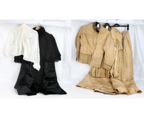 A group of early 20th century ladies' clothing including black cape and gold jacket, shirt and skirt.