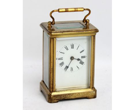 A French brass cased carriage clock, the circular dial set with Roman numerals, height excluding swing handle, 9.8cm with ori