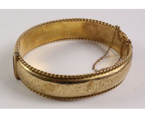 Gold hinged bangle, rope twist border and scroll decoration hallmarked 9ct approx 29.5gm Condition Report Click here for furt