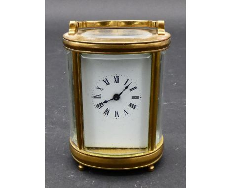 A miniature French brass five glass oval carriage clock with bevelled glass plates, white enamel dial with black Roman numera