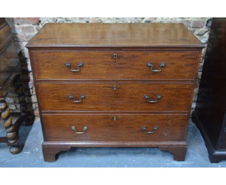 A George III mahogany three drawer chest, raised on shaped bracket feet