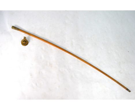 A malacca cane military swagger stick, the metal pommel stamped with Royal Marines badge, to/w a brass military cap badge (2)