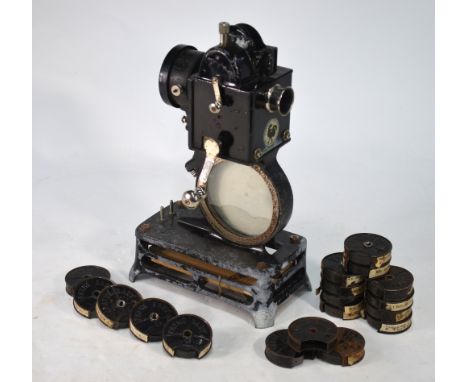 A French Pathe-Baby hand-cranked film projector, to/w a collection of film reels, including Harold Lloyd and Felix the Cat