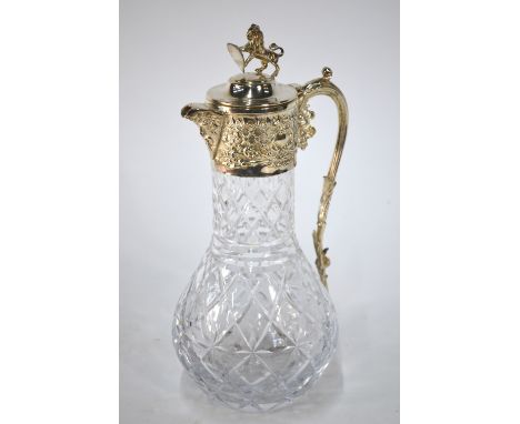 A cut glass claret jug with electroplated collar, hinged cover with lion finial and scroll handle