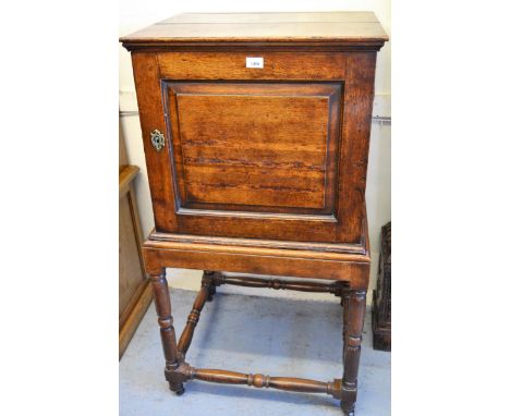 Small 18th Century oak cabinet on stand with a single fielded panel door enclosing four drawers on turned supports, 23.5 ins 