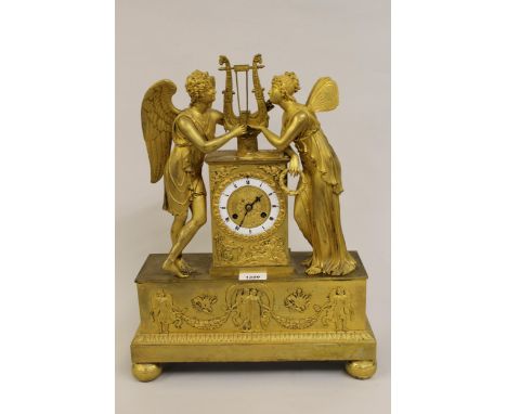 Early 19th Century French ormolu mantel clock, the circular enamel dial flanked by two figures of angels, the dial inscribed 