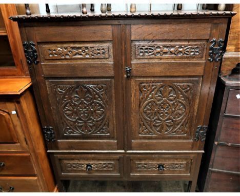 19th Century oak side cabinet with a pair of carved panel doors above two drawers and rectangular carved supports, 44ins wide