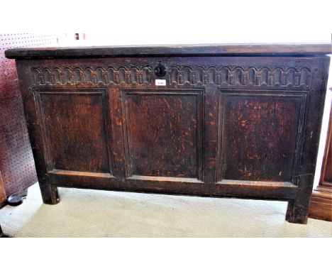 17th Century oak coffer, the hinged moulded plank lid above a carved frieze and three panel front on stile supports, 49ins wi