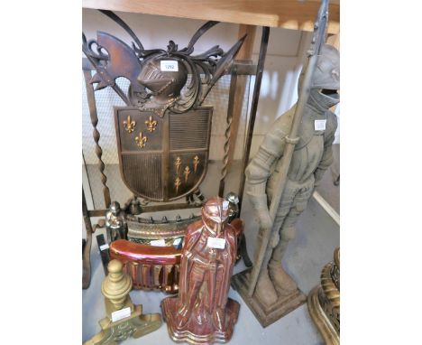20th Century iron fireguard mounted with a shield and knights helmet, together with a similar companion stand in the form of 