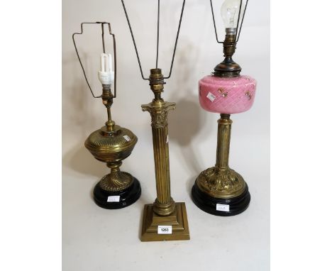 Brass Corinthian table lamp, another brass oil lamp converted to electricity and another with glass well 