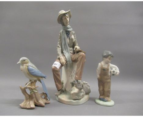 Lladro figure of a violinist sitting on a 48km milestone, Nao figure of a young boy with a football and another similar figur