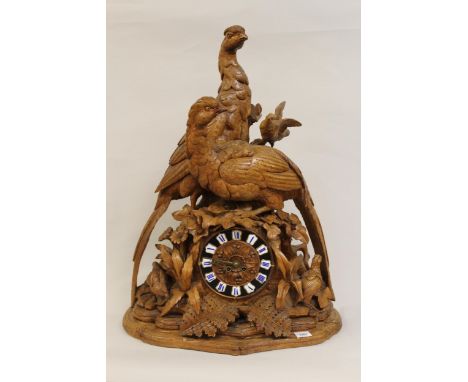 Large 19th Century Black Forest mantel clock, carved with figures of pheasants in foliage, the dial with enamel numerals and 