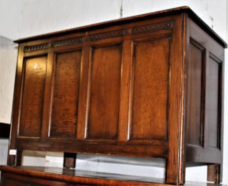 1930's Oak coffer, the hinged cover, above a four panel front on stile supports 