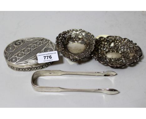 Two small silver trinket dishes, pair of silver sugar tongs and a Continental white metal oval filigree box with hinged cover