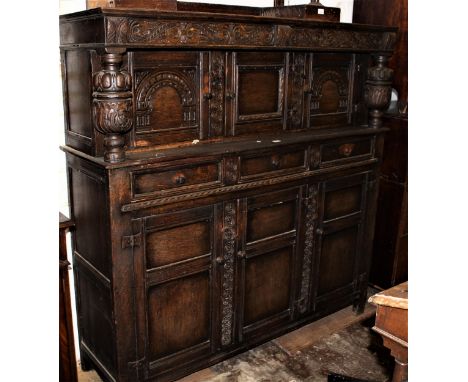 Mid 20th Century oak court cupboard, the top with three carved panelled doors flanked by turned carved pilasters, above three