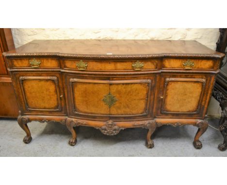 Gillows of Lancaster, mid 20th Century figured walnut semi bow front sideboard, the carved moulded top above three drawers an