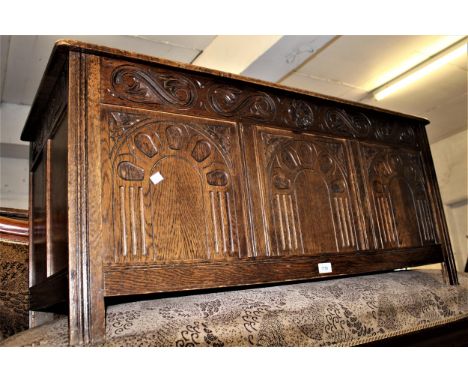 Reproduction oak coffer, with a hinged cover above a three panel front 