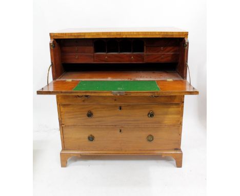 A GEORGE III MAHOGANY SECRETAIRE CHEST with secretaire drawer over three long drawers, all with brass ring handles and standi