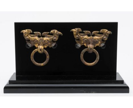A pair of Chinese gilt-metal mask ring handles: each loose ring suspended from a taotie head cast in relief with claws, prono