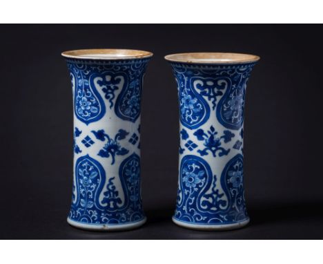 A pair of Chinese blue and white sleeve vases: painted with lotus blooms between bold ruyi-head and floral borders, Kangxi, 1