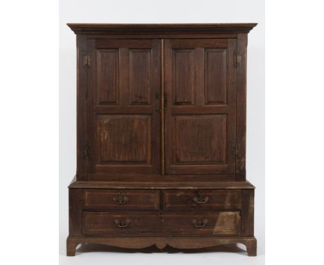 An 18th Century oak side cupboard:, the upper part with a moulded cornice, enclosed by a pair of fielded panel doors, the low