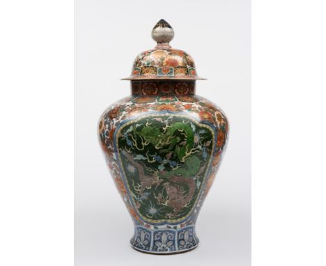 A large Japanese Imari vase and domed cover: enamelled front and verso with panels of green and aubergine dragons in combat, 