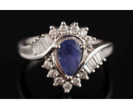 A tanzanite and diamond cross-over cluster ring: the single pear-shaped tanzanite within a surround of baguette-cut and circu