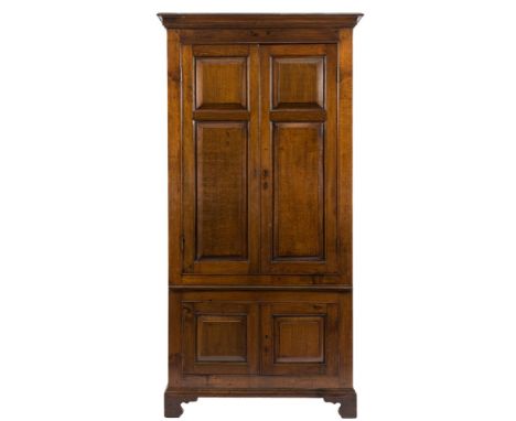 A 19th Century oak hall cupboard:, with a moulded cornice and interior hooks and rail for hanging, enclosed by a pair of moul