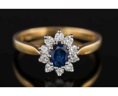 An 18ct gold, sapphire and diamond oval cluster ring: with central oval sapphire approximately 5.5mm x 4.3mm estimated to wei