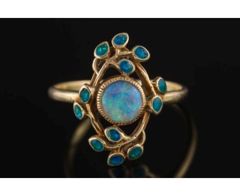 An Arts and Crafts enamelled 15ct gold and opal single-stone ring: with central circular opal 6mm diameter within a foliate p